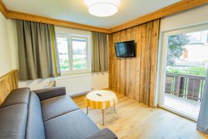 a living room with a couch and a table at Hotel Pehab - Rooftop-Spa in Ramsau am Dachstein