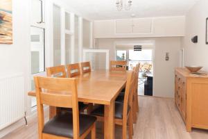 a kitchen and dining room with a wooden table and chairs at Alpine Cottage in Bigbury on Sea