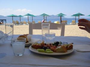 a plate of food on a table on the beach at Kochili Apartments in Neos Pirgos