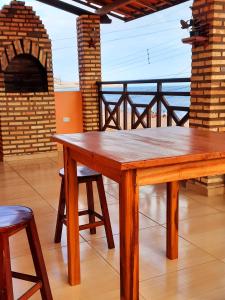 une table en bois avec deux chaises et un four en briques dans l'établissement Hospedagem da Cleidiane, à Icapuí