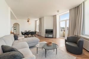 a living room with a couch and chairs and a table at Residence Palace Style app in a unique building in Zeebrugge