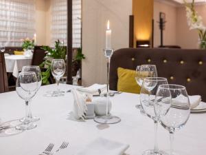 een tafel met wijnglazen en een kaars erop bij Park Hotel in Chmelnytsky