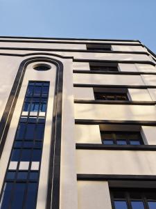 a tall white building with black windows at Vanoro Hotel in Thessaloniki