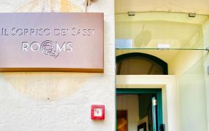 a sign on the wall of a building at Il Sorriso Dei Sassi Rooms in Matera
