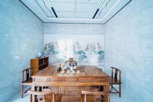 uma sala de jantar com uma mesa de madeira e 2 cadeiras em Longhushan Hanxiangju Homestay em Yingtan
