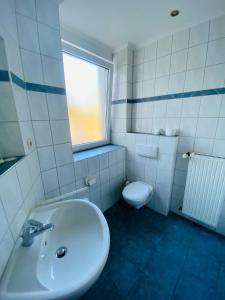 a white bathroom with a sink and a toilet at Hotel Montan in Duisburg