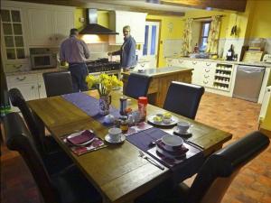 a kitchen with a wooden table and two men in the kitchen at The Old Mill in Wooler