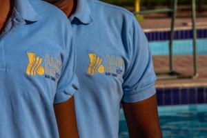 拉斯蘇德爾的住宿－Golden Beach 1 Ras Sedr，两人穿着蓝色衬衫站在游泳池旁边