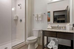 a bathroom with a toilet a sink and a shower at MainStay Suites Cincinnati University - Uptown in Cincinnati