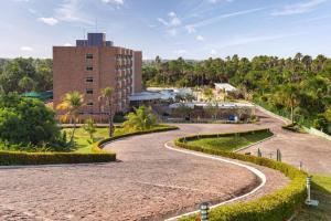 um caminho num parque com um edifício ao fundo em Grand Lençóis Flat em Barreirinhas