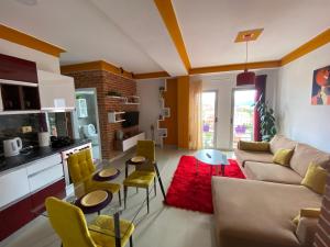 a living room with a couch and a red rug at Your Apartment in Pogradec