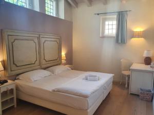 Un dormitorio con una gran cama blanca y una ventana en Hotel Villa Moron, en Negrar