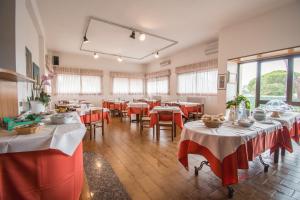 a restaurant with tables with red and white tablecloths at Hotel Cantalodole in Magione