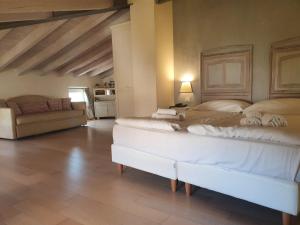 a large bedroom with two beds and a couch at Hotel Villa Moron in Negrar