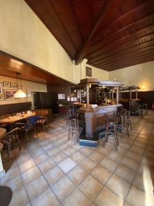 a restaurant with tables and chairs and a kitchen at Hotel Montan in Duisburg