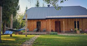 a log cabin with a hammock in front of it at Dusza Chata w Bieszczadach in Myczkowce