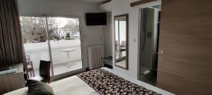 a bedroom with a bed and a mirror and a window at Logis Hôtel Les Bleuets in Royan