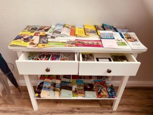 a white table filled with magazines and books at mitten im dorf in Worpswede
