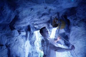 Um homem está numa caverna com uma cascata. em Waldhotel Doldenhorn em Kandersteg