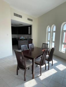 a dining room with a wooden table and four chairs at Expo Backpackers in Dubai