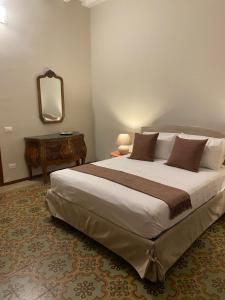 1 dormitorio con 1 cama grande y espejo en Galli Beach House Sicily, en Trapani