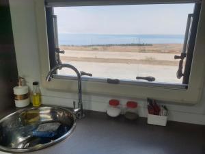 a sink and a window with a view of the desert at Ein Gedi caravan by Dory caravan in Ein Gedi