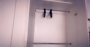 a white closet with black hangers on the wall at Lovely 2 Rooms apartment in the CENTER of the city in Bucharest