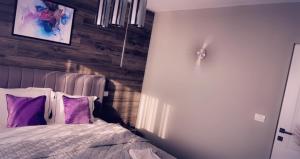 1 dormitorio con 1 cama con almohadas moradas en Lovely 2 Rooms apartment in the CENTER of the city, en Bucarest