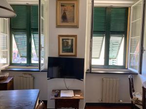 Sala de estar con persianas verdes y TV en LIGURIA HOLIDAYS - La casetta sul porticciolo, en Camogli