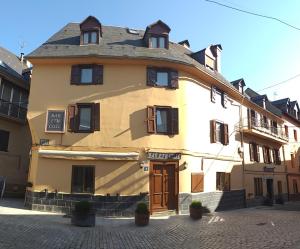 a large yellow building with a roof at Pension Casa Vicenta in Vielha