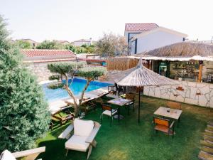 an outdoor patio with tables and chairs and a pool at Signature Alaçatı in Alacati