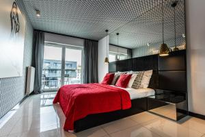 sypialnia z dużym łóżkiem i czerwonym kocem w obiekcie Apartamenty Homely Place - Parking w Poznaniu