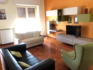 ein Wohnzimmer mit einem Sofa und einem TV in der Unterkunft Casa Centrale- Holiday House in Matera