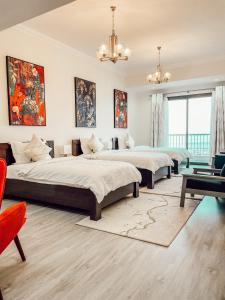 2 camas num quarto grande com um lustre em Mina AlFajer Apartments em Dibba