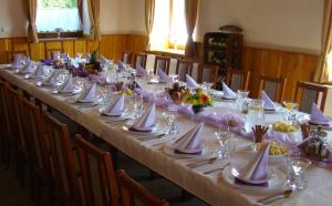 una mesa larga con platos blancos y servilletas. en Penzion a restaurace U Maryny, en Bocanovice