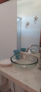 a bathroom sink with a glass bowl on a counter at Hostel Amicum in Massarandupio