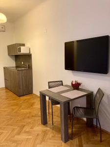 盧比安納的住宿－Twix apartment，用餐室配有桌椅和平面电视。