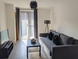 a living room with a couch and a table at Suffield Lodge by Wycombe Apartments in High Wycombe