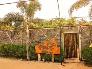 een bord voor een gebouw met een palmboom bij Pousada Barra del Mundo in Barra Grande