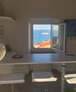 a desk with two chairs and a window at Appartamento La Serra di Angela a Lerici in Lerici