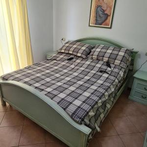 a green bed with a checkered blanket on it at Appartamento Ai Tigli in Caorle