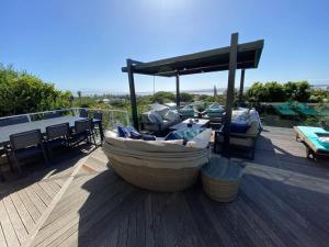 a boat sitting on top of a wooden deck at Lasalle holiday home (Sun, Beach, Views, Fun for everyone!) in Plettenberg Bay