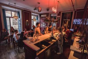 eine Gruppe von Personen, die in einer Bar in einem Restaurant sitzen in der Unterkunft Home Lisbon Hostel in Lissabon
