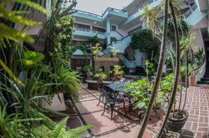 un patio con mesa, sillas y plantas en Hotel Michelle, en San Andrés Tuxtla