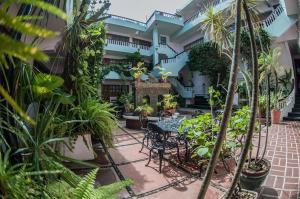 einen Innenhof mit einem Tisch, Stühlen und Pflanzen in der Unterkunft Hotel Michelle in San Andrés Tuxtla