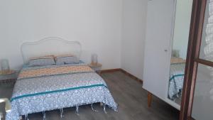 um quarto com uma cama e duas mesas e um espelho em LA PETITE MAISON em Saint-Loup-Géanges