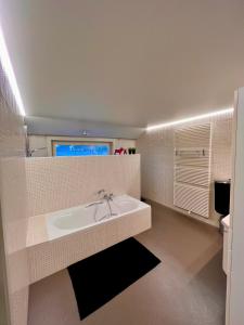a white bathroom with a sink and a mirror at Loft to go in Zedelgem