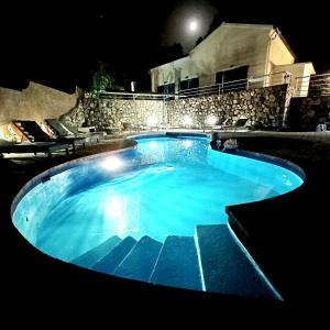 una grande piscina di notte di Casa Nuova a Liapades