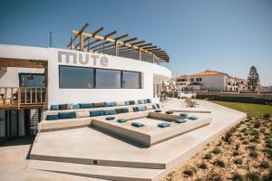 a building with couches on the side of it at MUTE Hostel Porto Covo in Porto Covo