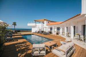 a villa with a swimming pool and a patio at MUTE Hostel Porto Covo in Porto Covo